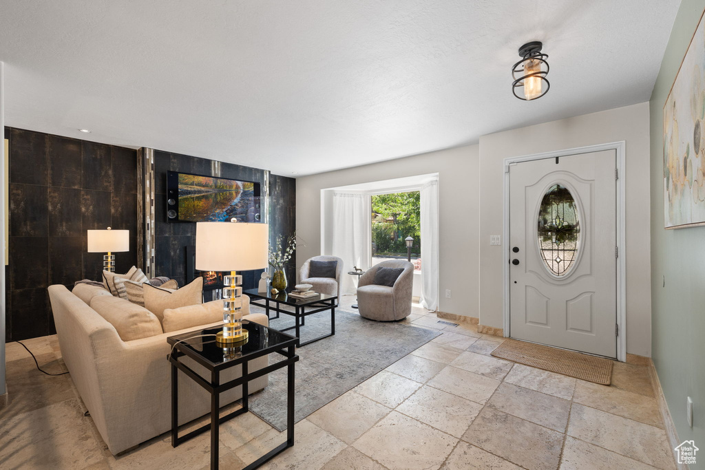 Foyer entrance with stone tile flooring and baseboards