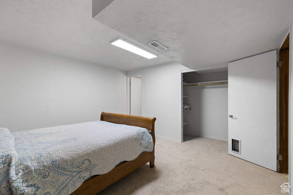 Bedroom featuring carpet flooring, a closet, and a textured ceiling