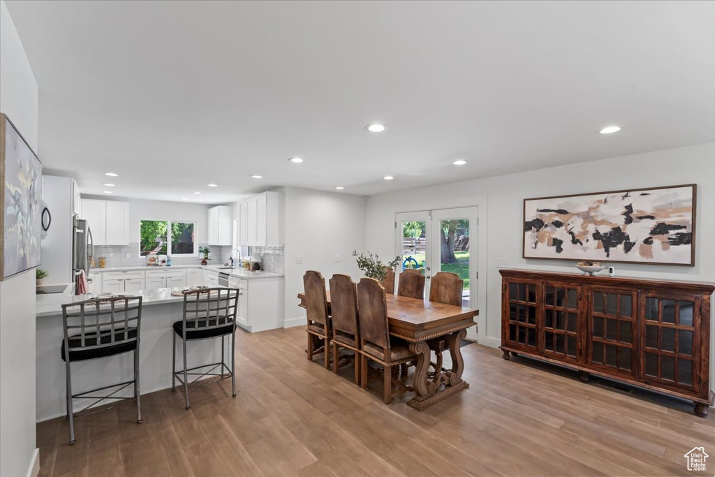 Dining space with light wood-style floors and recessed lighting