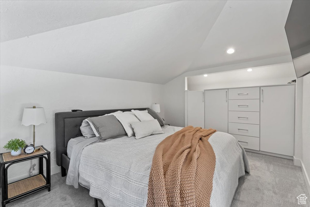 Bedroom featuring light carpet, vaulted ceiling, recessed lighting, and a closet