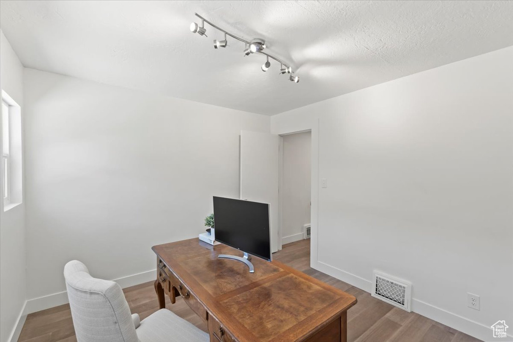 Office area featuring light wood-type flooring and track lighting