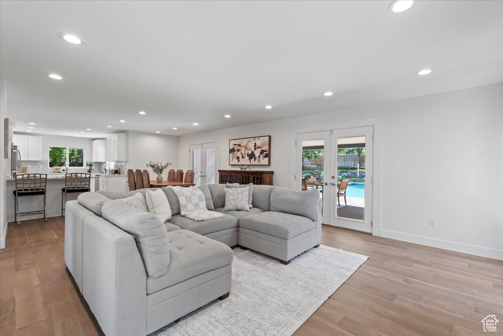 Living room with recessed lighting, french doors, and light wood-style flooring
