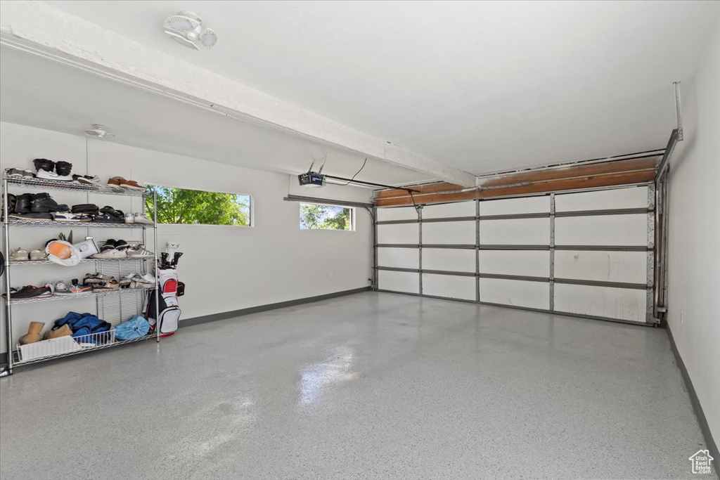 Garage featuring baseboards and a garage door opener