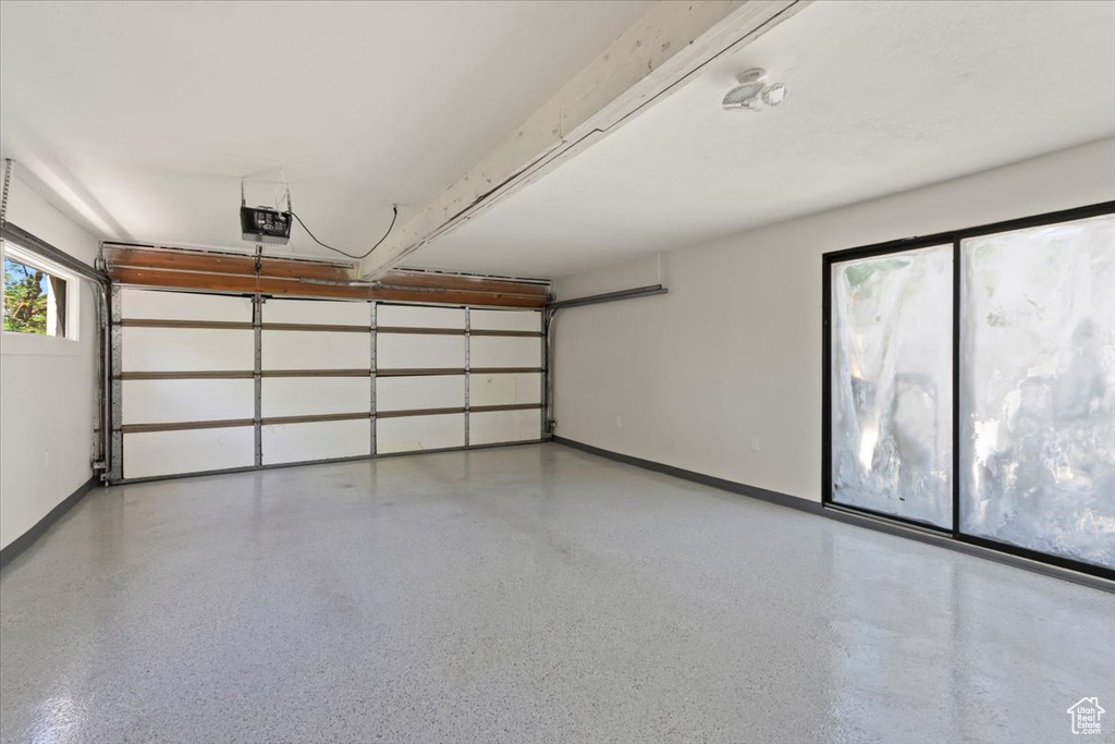 Garage with baseboards and a garage door opener