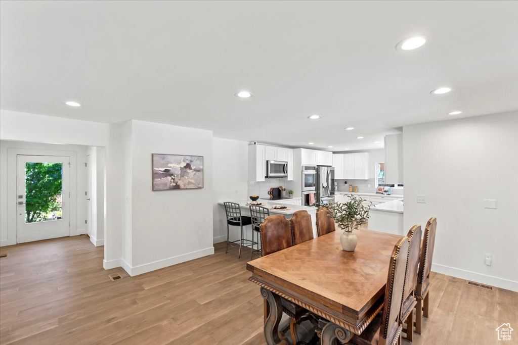 Dining space with light wood-style flooring and recessed lighting