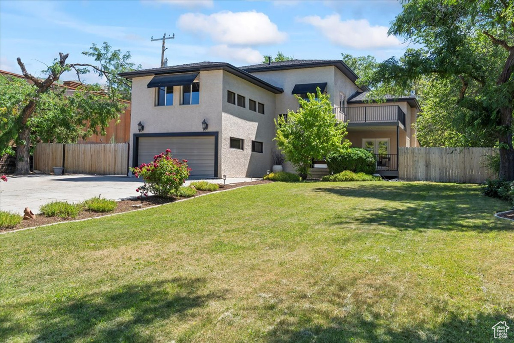 View of front of home with an attached garage, driveway, and stucco siding