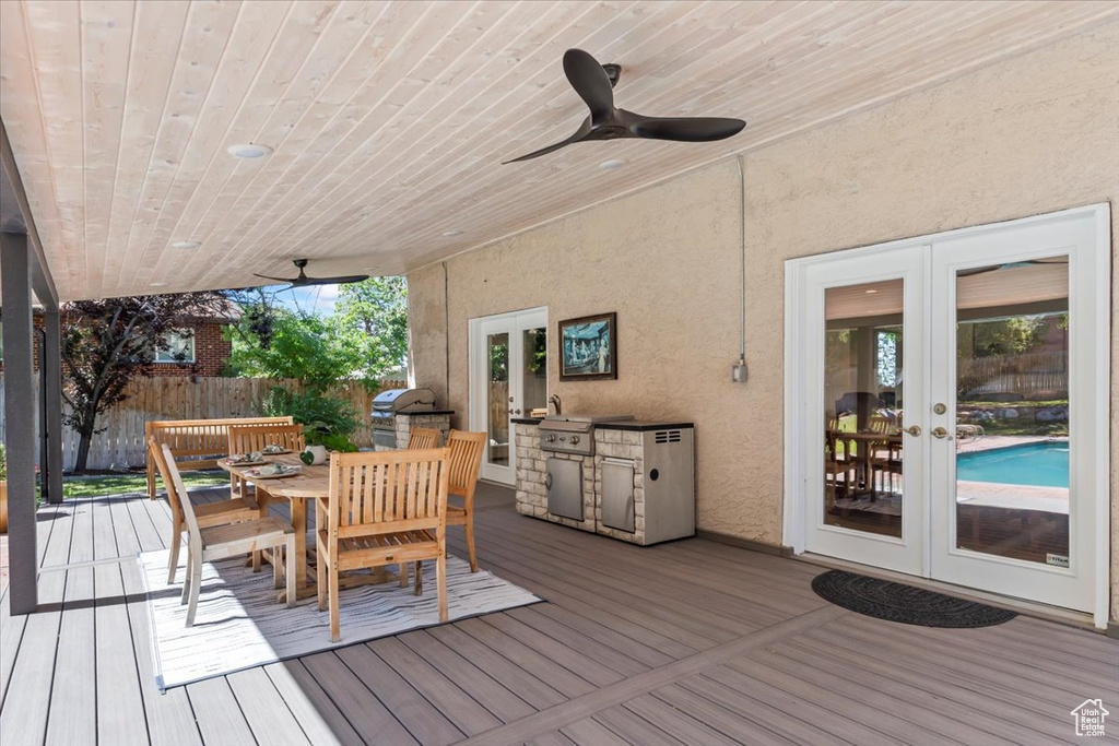 Deck with french doors, exterior kitchen, outdoor dining area, and a ceiling fan