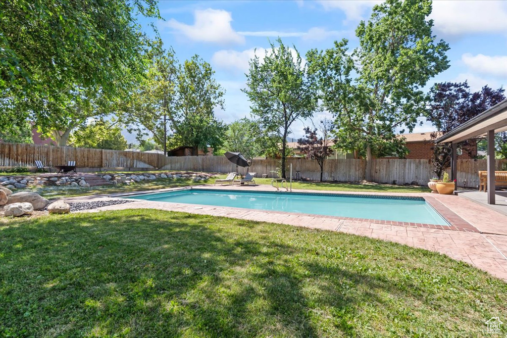 View of swimming pool with a fenced backyard and a patio