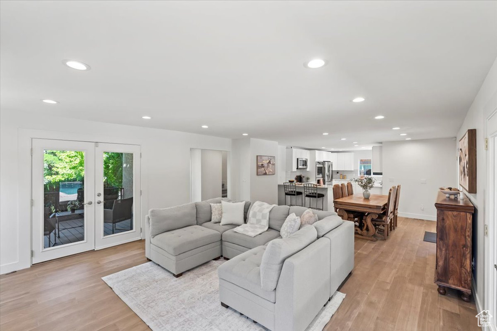 Living area with recessed lighting, light wood finished floors, and french doors