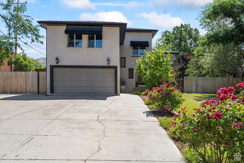 Contemporary home with an attached garage, driveway, and stucco siding