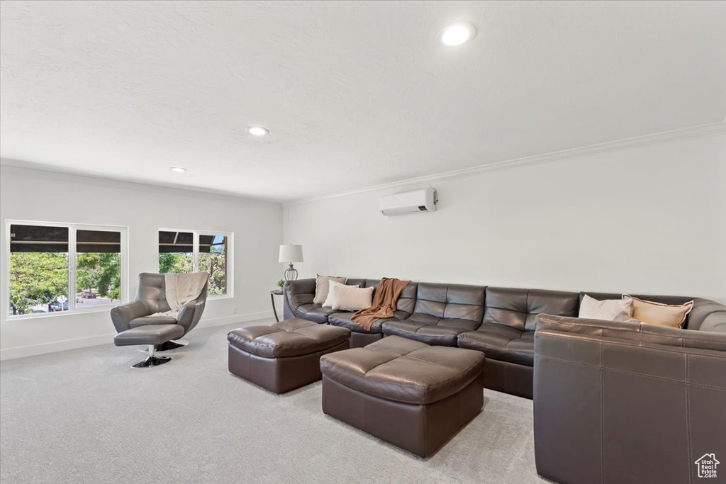 Carpeted living area with a wall unit AC, ornamental molding, and recessed lighting