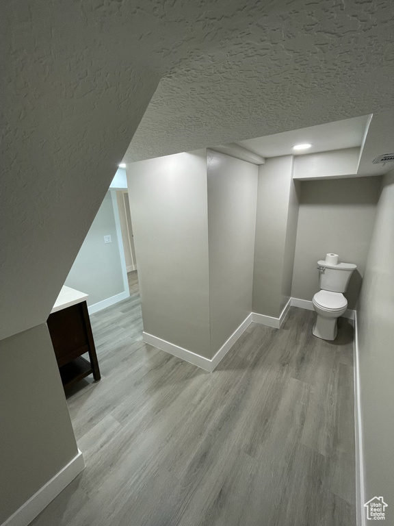 Hallway with wood finished floors and a textured ceiling