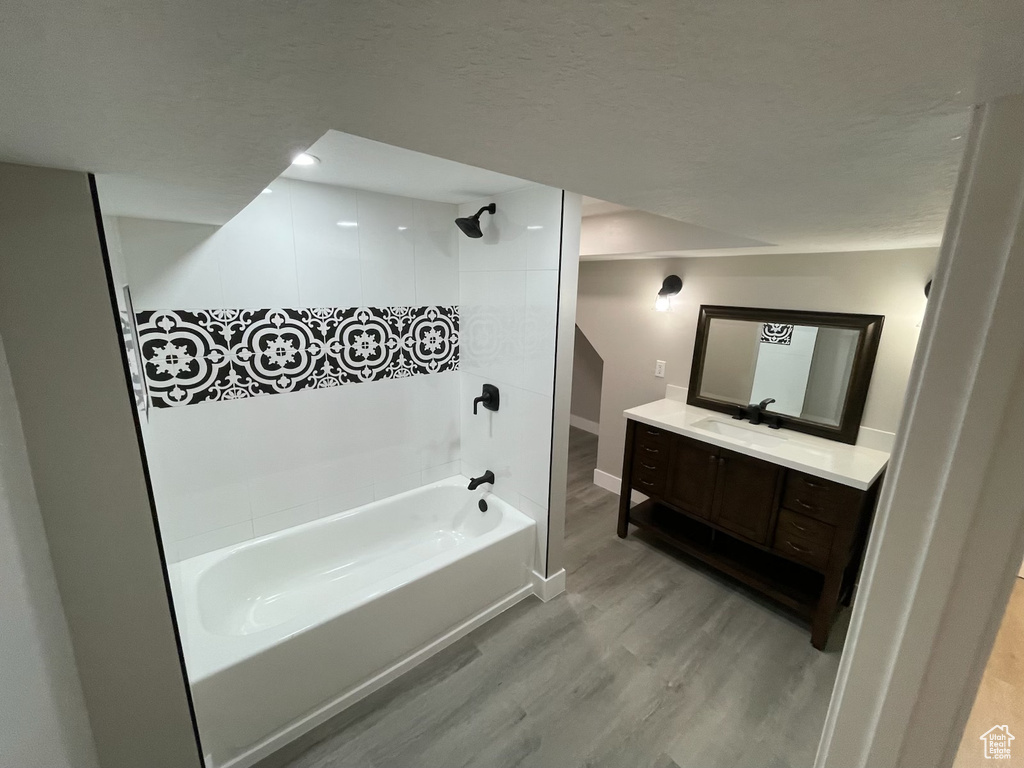 Full bathroom featuring wood finished floors,  shower combination, and vanity