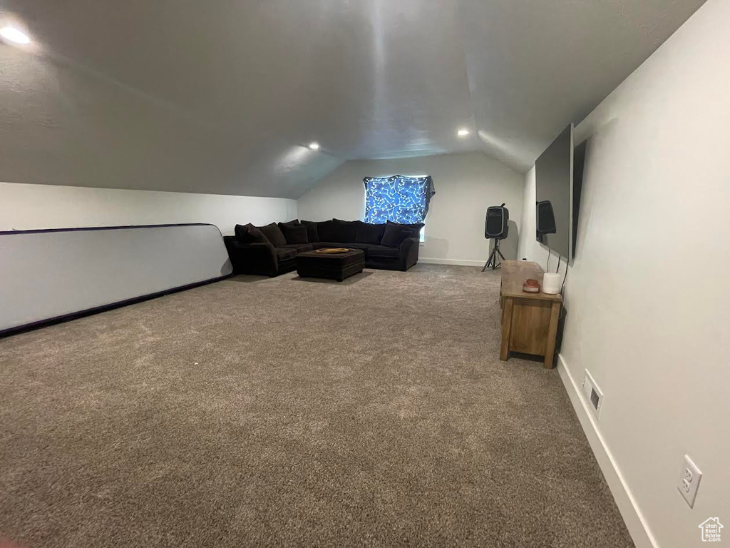Living area with carpet and lofted ceiling