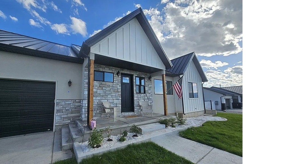 View of front of house featuring a standing seam roof, a metal roof, and an attached garage