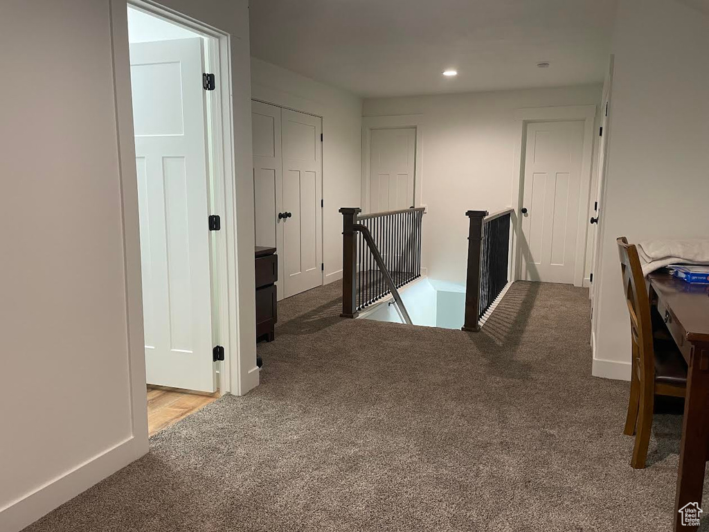 Hall with carpet floors, an upstairs landing, and recessed lighting