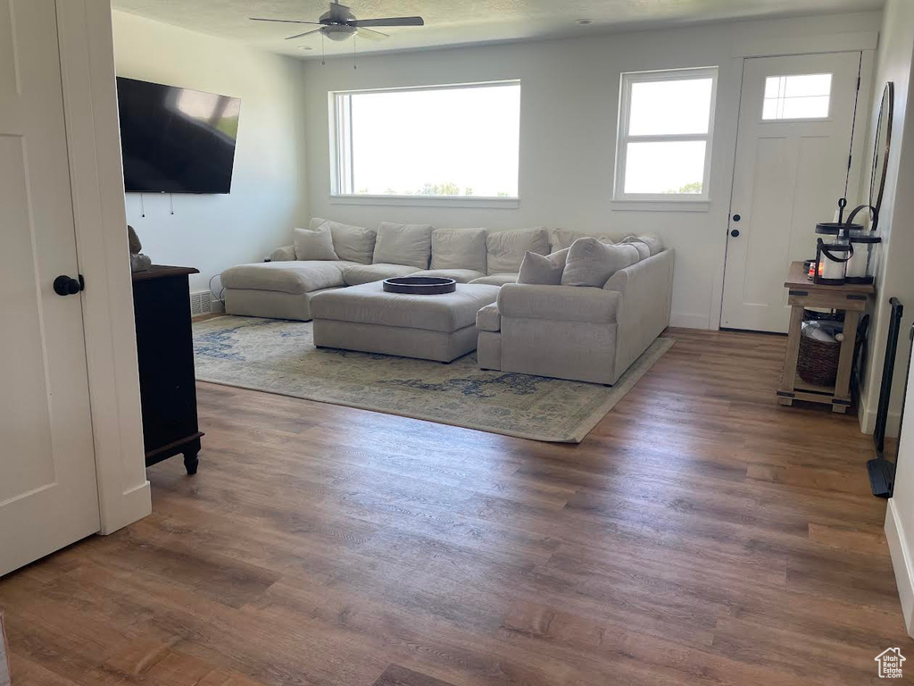 Living area with ceiling fan and wood finished floors