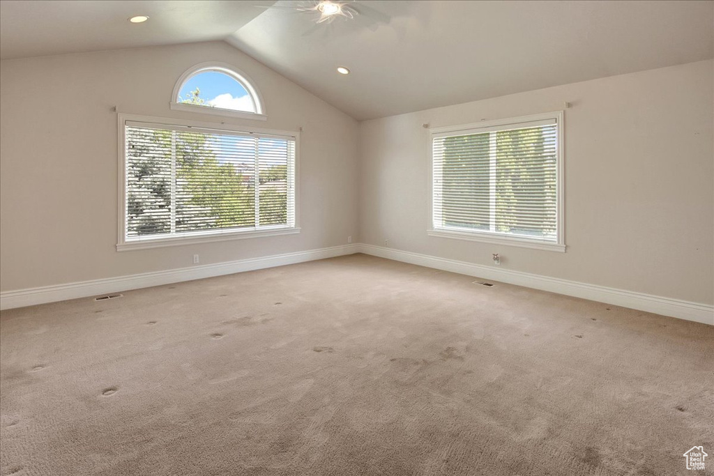 Unfurnished room featuring vaulted ceiling, light colored carpet, and recessed lighting