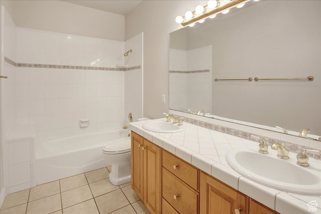 Full bath with double vanity, tub / shower combination, and tile patterned flooring