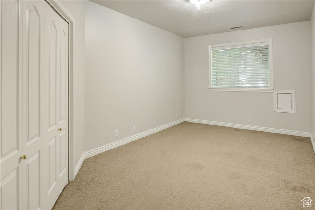 Unfurnished bedroom featuring light colored carpet and a closet
