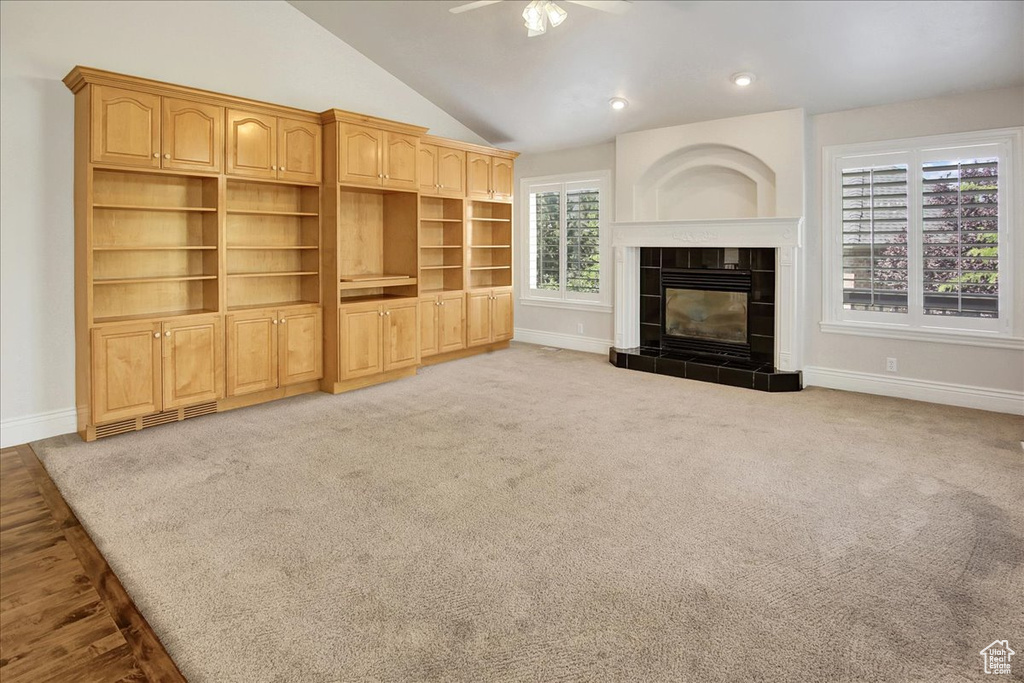 Unfurnished living room with a ceiling fan, lofted ceiling, a fireplace, carpet, and recessed lighting