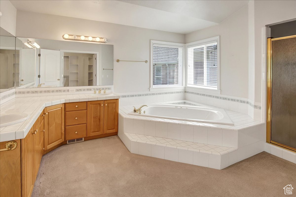 Full bath featuring a stall shower, double vanity, a garden tub, and carpet flooring