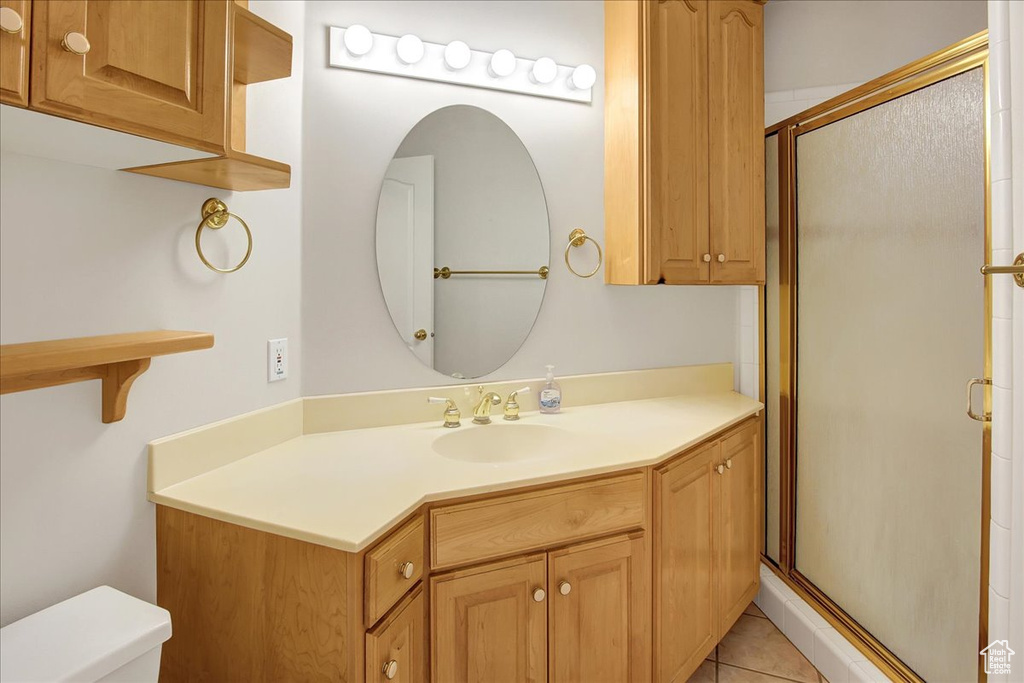 Full bath featuring a stall shower, vanity, and tile patterned flooring