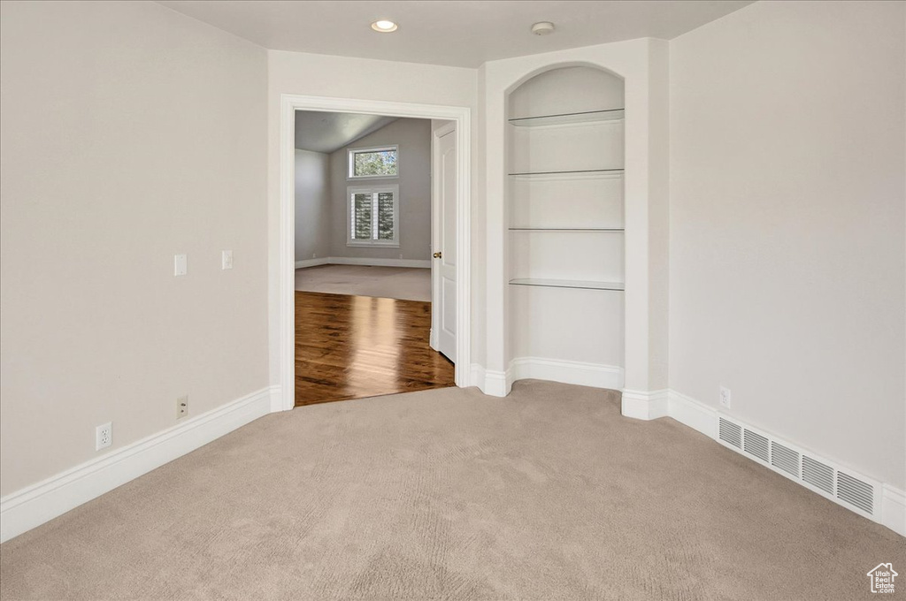 Carpeted empty room featuring built in features, recessed lighting, and a smoke detector