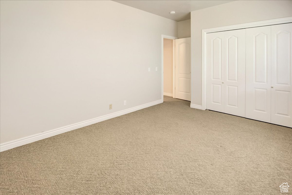 Unfurnished bedroom featuring carpet and a closet