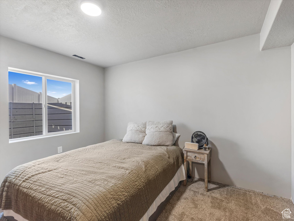 Carpeted bedroom featuring a textured ceiling