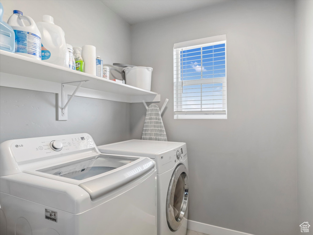 Laundry area featuring separate washer and dryer and baseboards