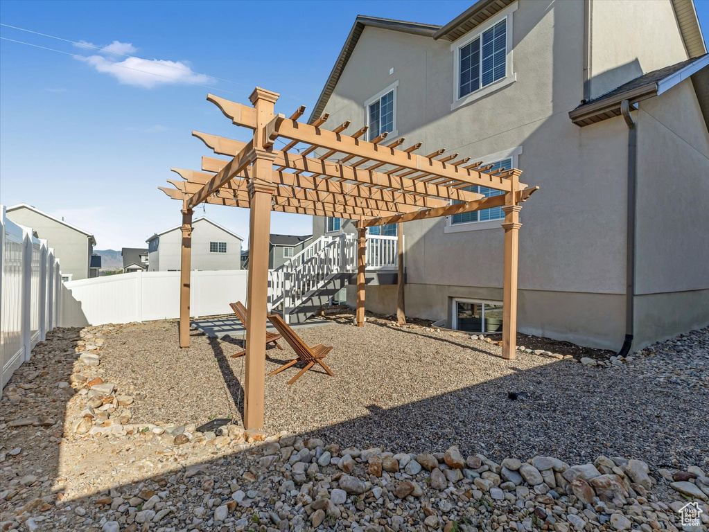 Fenced backyard featuring a pergola