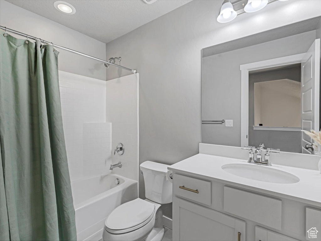 Full bathroom featuring shower / bathtub combination with curtain, vanity, and recessed lighting