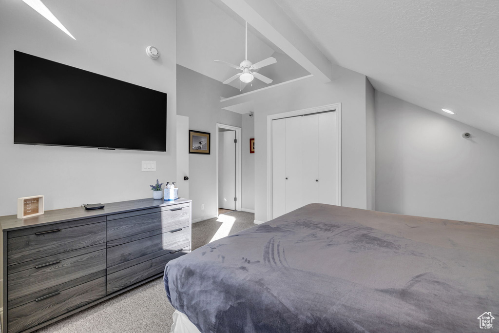 Bedroom with light carpet, a ceiling fan, and a closet