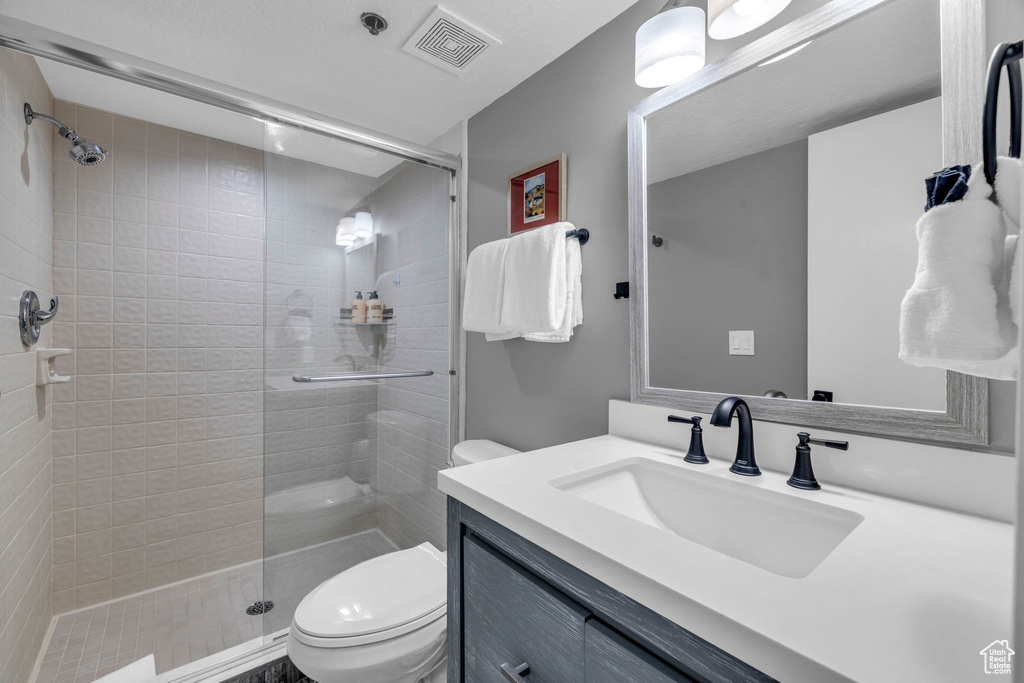 Full bath featuring a stall shower and vanity