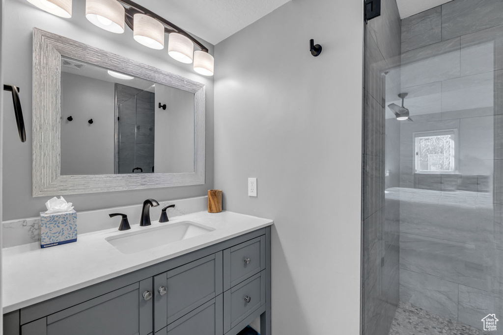 Full bathroom featuring vanity and tiled shower
