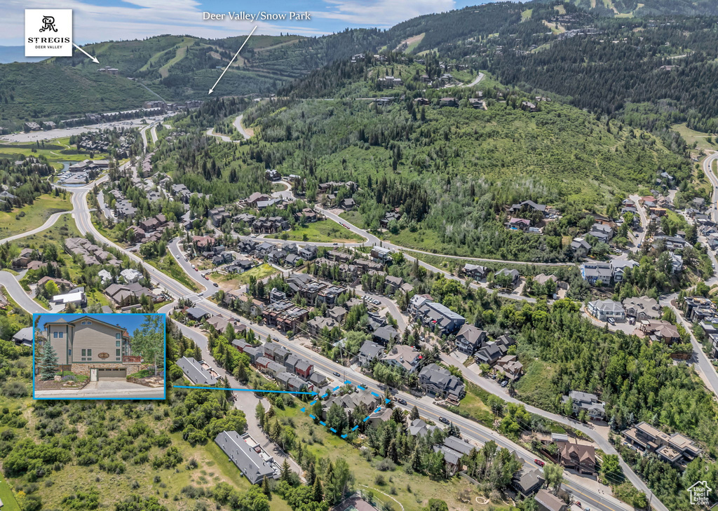 Aerial view of residential area with a mountain backdrop and property boundaries highlighted