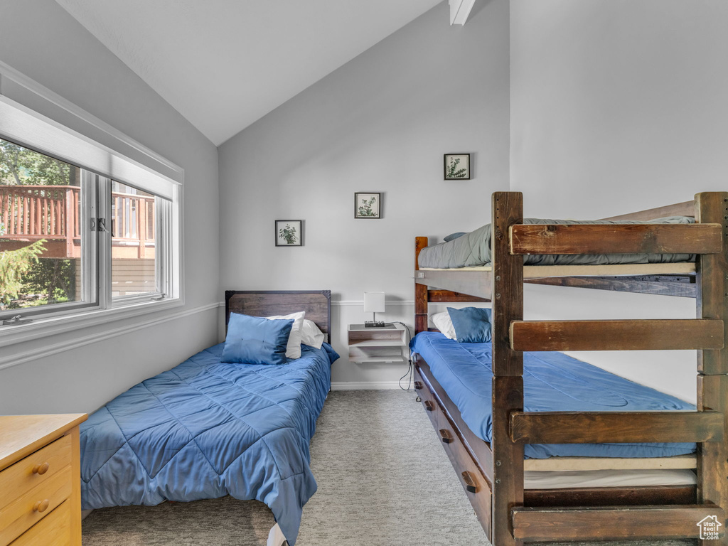 Carpeted bedroom featuring lofted ceiling and baseboards