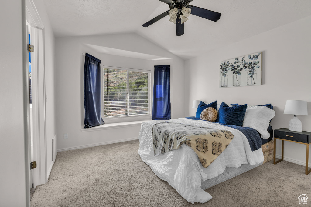 Carpeted bedroom featuring lofted ceiling and ceiling fan