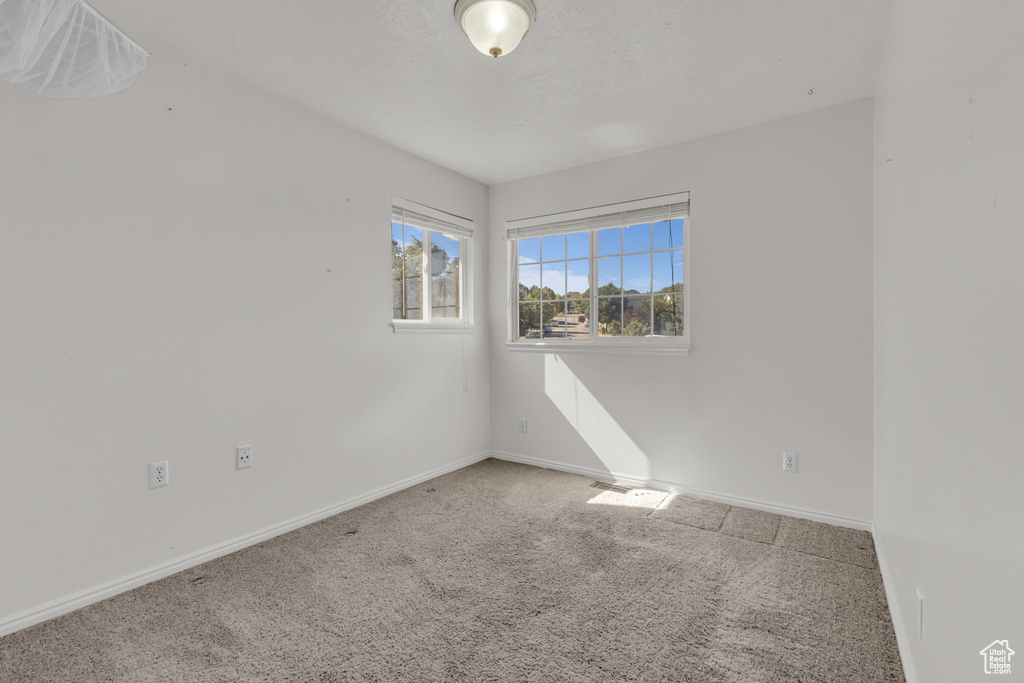 Carpeted empty room featuring baseboards