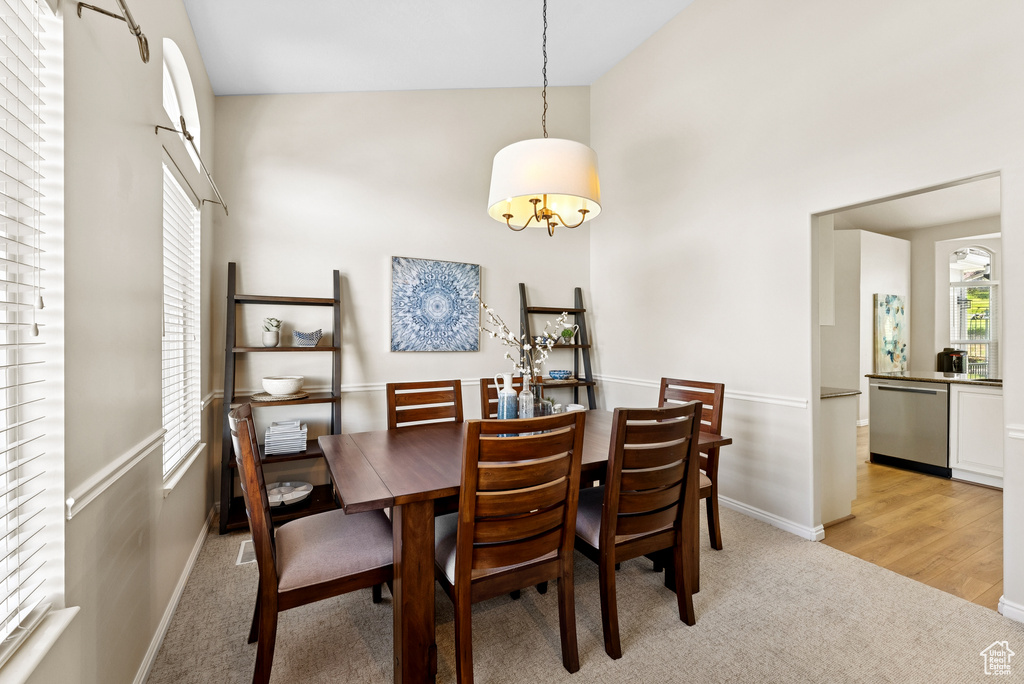 Dining room with light colored carpet and a towering ceiling