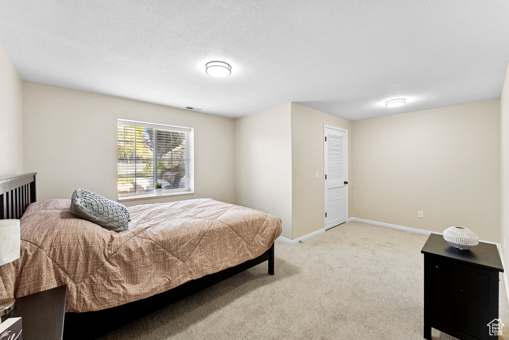 Bedroom with light colored carpet and baseboards