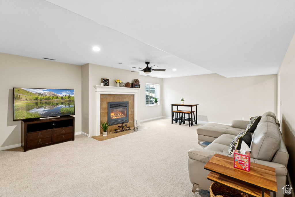 Carpeted living room featuring ceiling fan, a fireplace, and recessed lighting