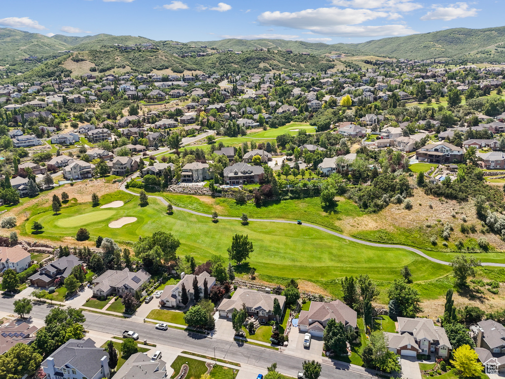 Aerial perspective of suburban area with a mountainous background and a golf course