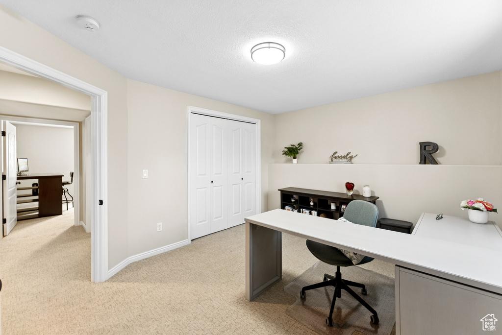 Office space featuring light carpet and baseboards