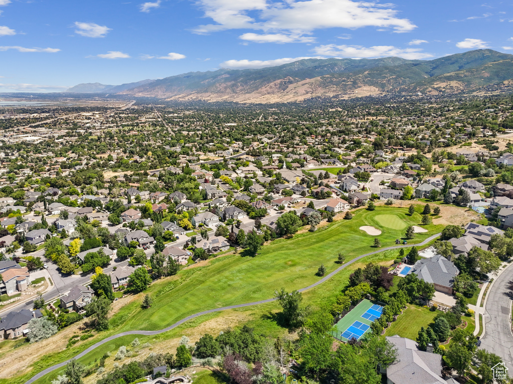 Aerial view of residential area featuring a mountainous background and a local golf course