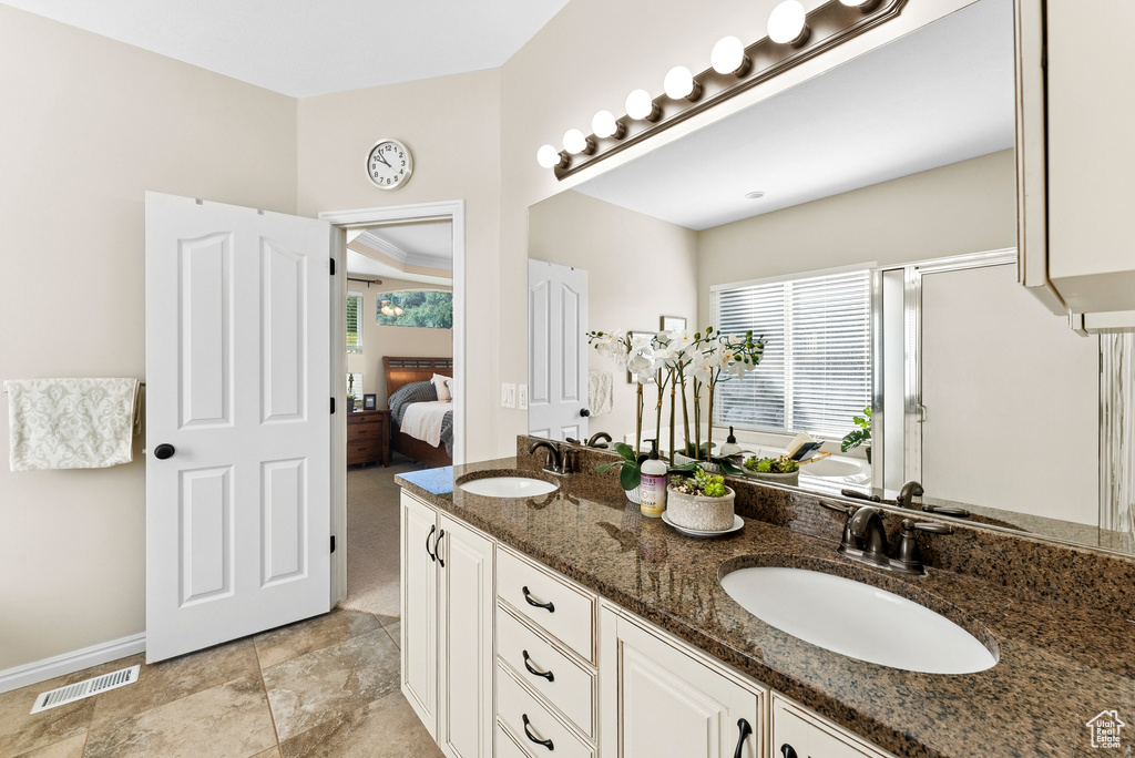 Ensuite bathroom featuring double vanity and a shower with door