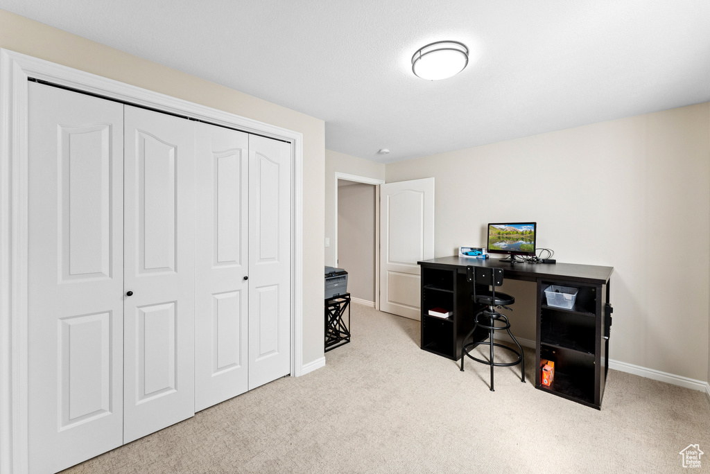 Carpeted home office featuring baseboards