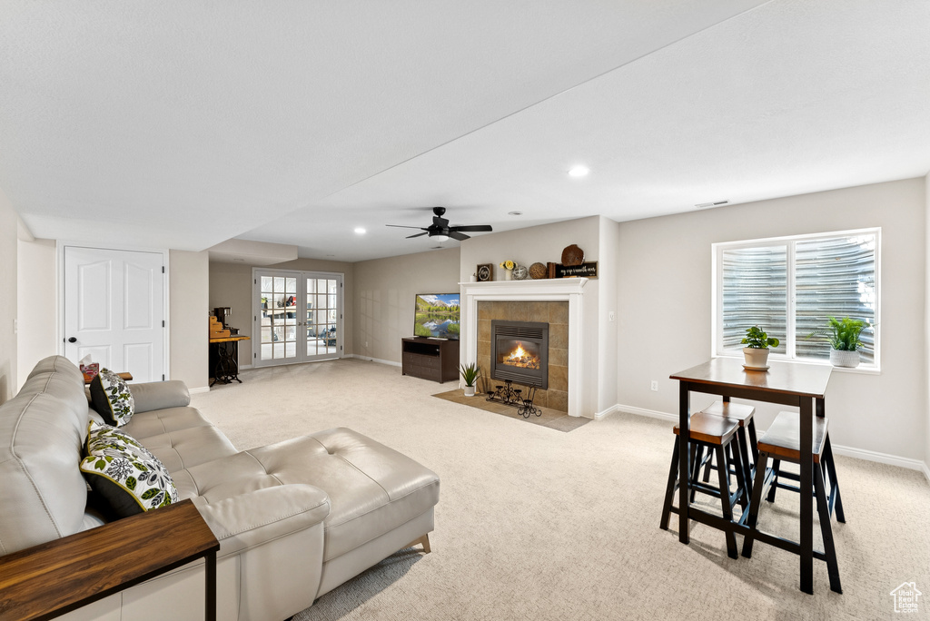 Living room featuring light carpet, a tile fireplace, a ceiling fan, and recessed lighting