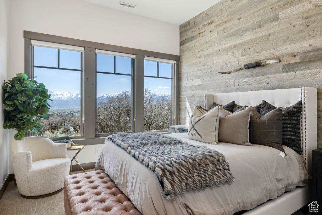 Bedroom with wooden walls and multiple windows
